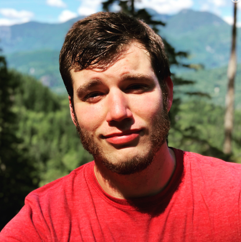 Cole Demas outdoors with mountains in the background.